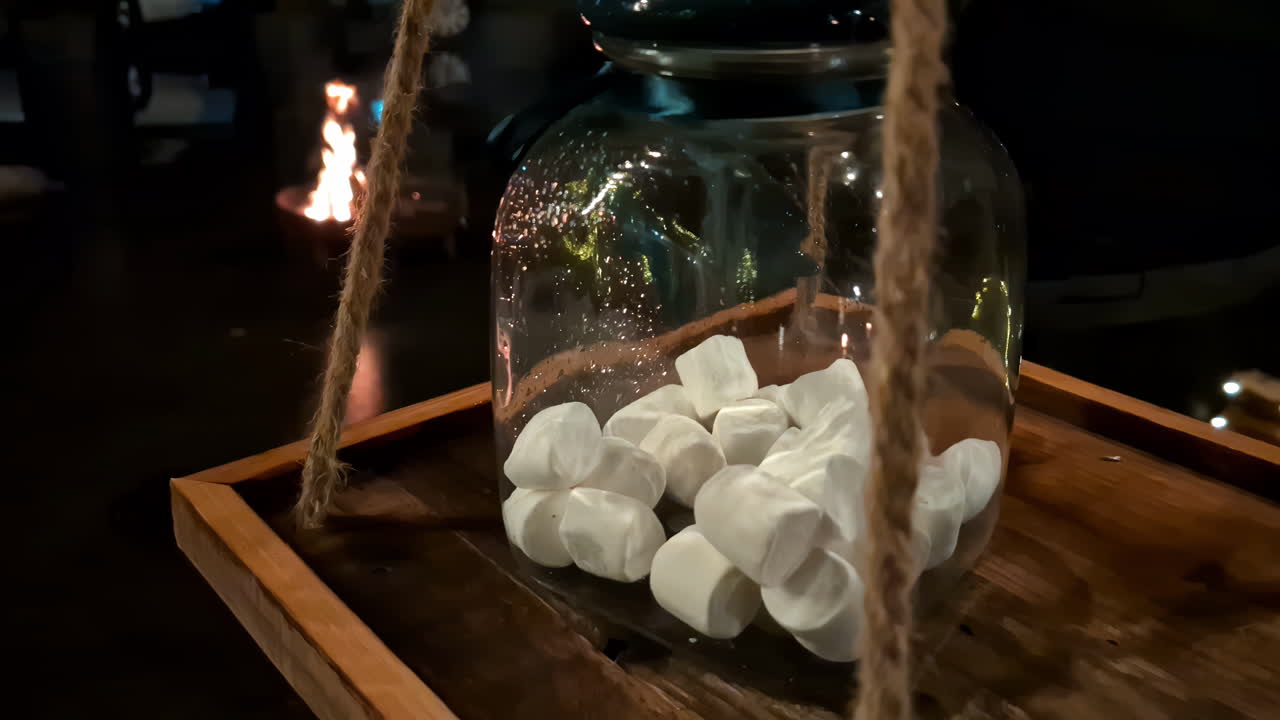 Marshmallow bianchi all'interno di un grande barattolo di vetro, pronti per essere arrostiti sul fuoco da campo