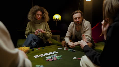 gruppe von freunden, die auf der couch im wohnzimmer poker spielen 12