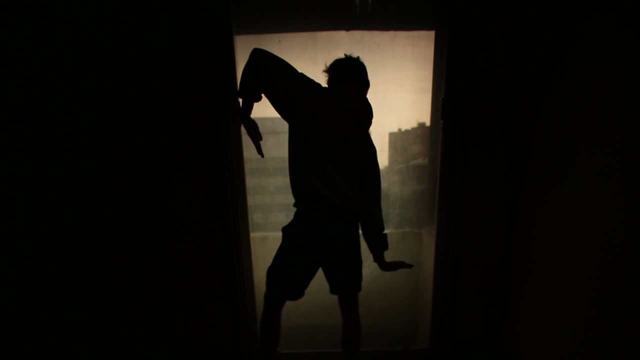 Silhouette of a Man in a Dark Room