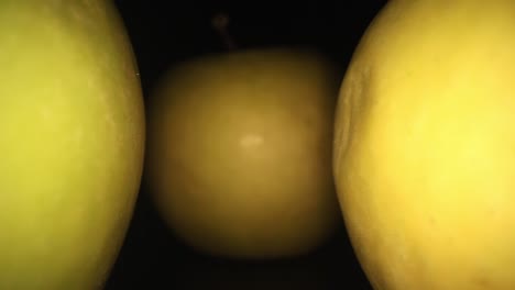 pulling away from an apple in the middle with 2 others, one on each side