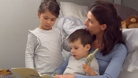madre leyendo cuentos a los niños en su dormitorio