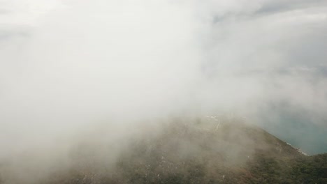 drone aerial inside the clouds on a tropical forest island