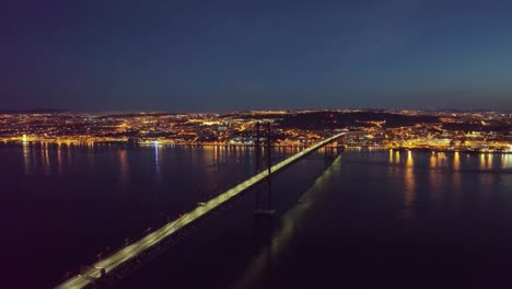 Drone-footage-panning-over-ponte-25-abril-and-river-Tejo-in-Lisbon,-before-sunrise