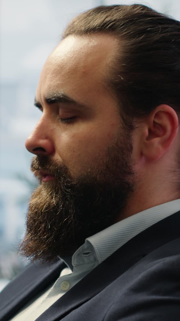 Video verticale CEO che si reclina sulla sua sedia da ufficio impegnato in una sessione di meditazione guidata