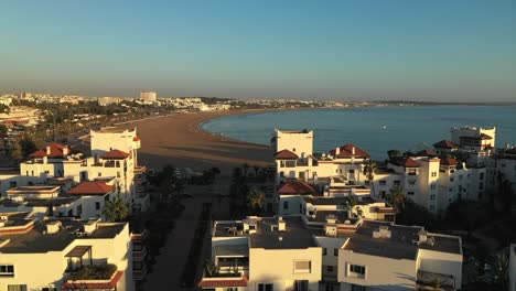 aerial view of agadir beachfront hotels and wide sandy beach at sunrise, morocco