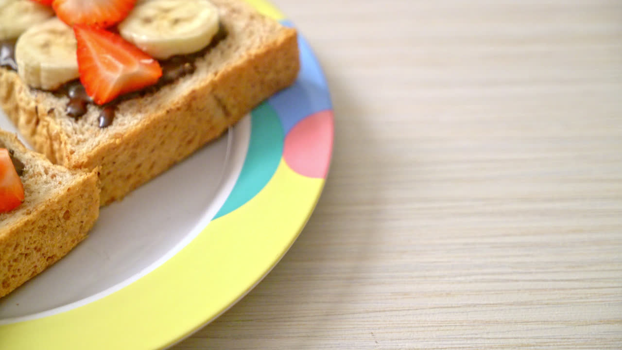 pan integral tostado con plátano fresco, fresa y chocolate para el desayuno