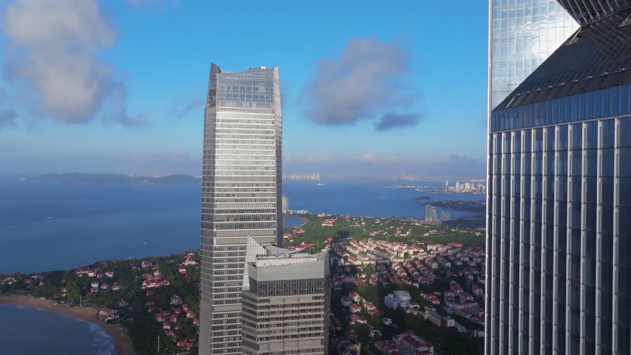 Fotografia aérea de um nascer do sol na costa de Qingdao, Shandong, China. Edifícios altos, com os primeiros raios de sol iluminando os prédios da cidade costeira