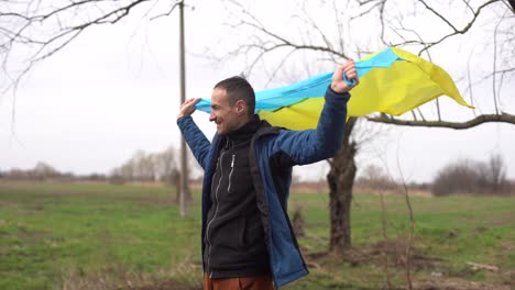 man-with-the-flag-of-Ukraine-near-the-burnt-tree