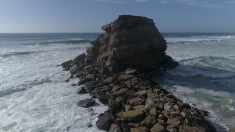 gran roca en el mar azul en un día soleado