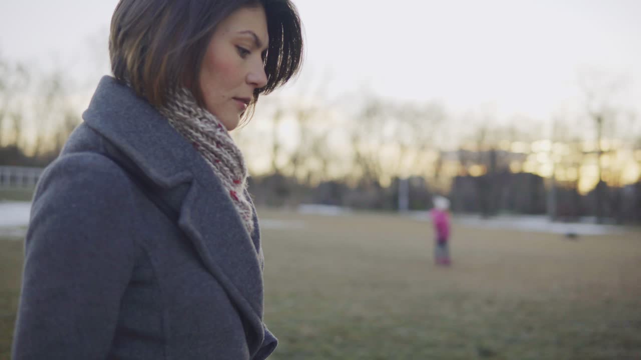 가을 코트를 입고 야외 공원을 산책하는 여자