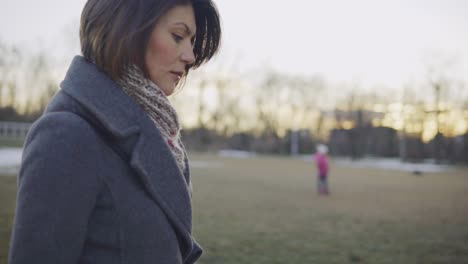 woman in autumn coat walking outdoors in park