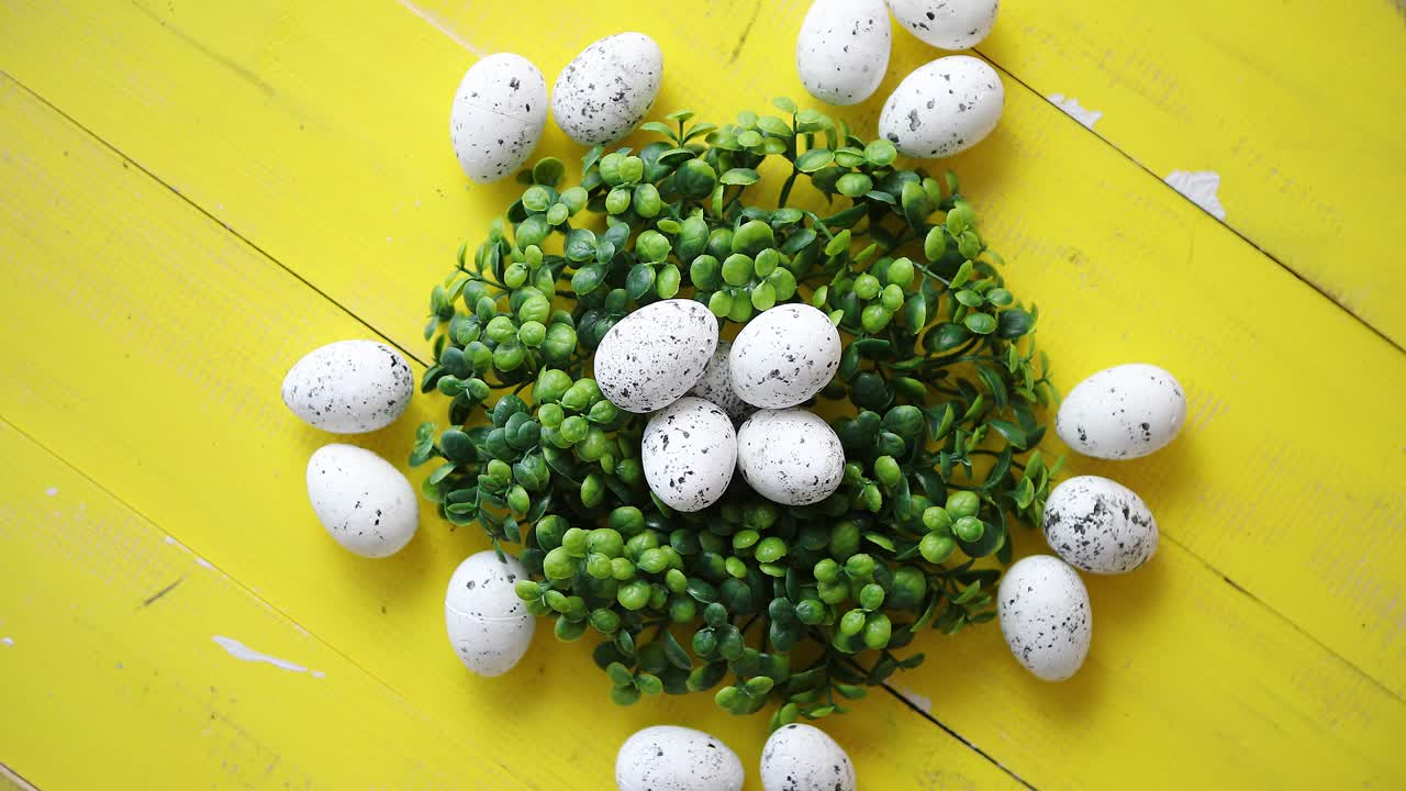 노란색 나무 테이블에 녹색 장식 부활절 메추라기 계란 화환