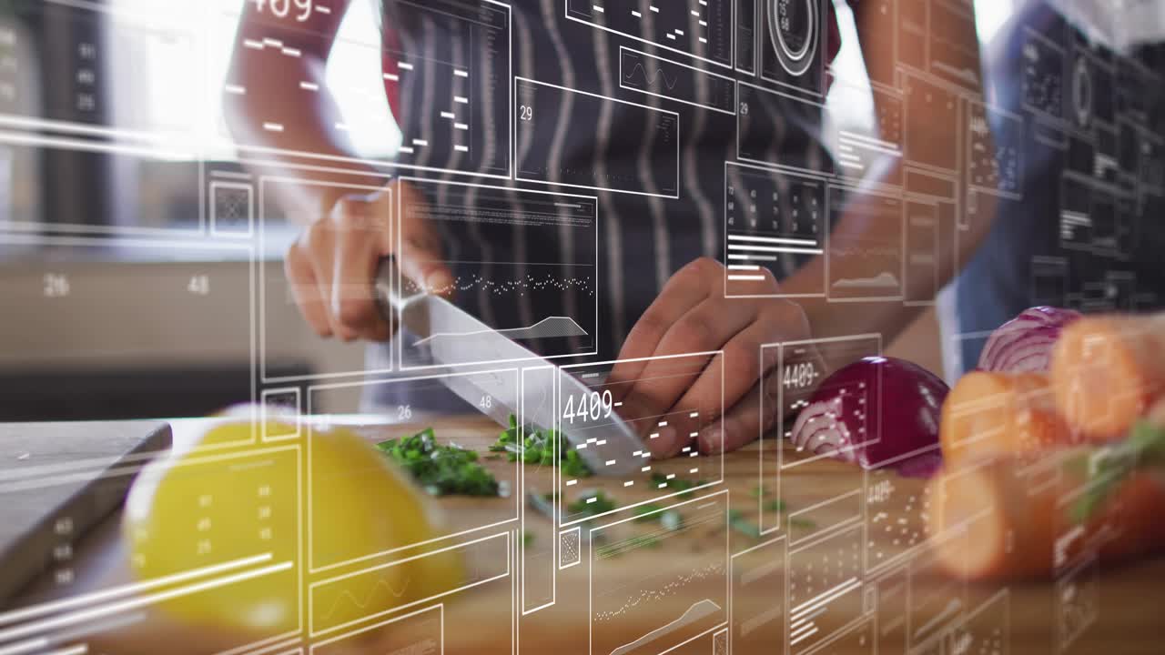 Woman lifting knife and chopping herbs for cooking on board near window as teen adding carrots