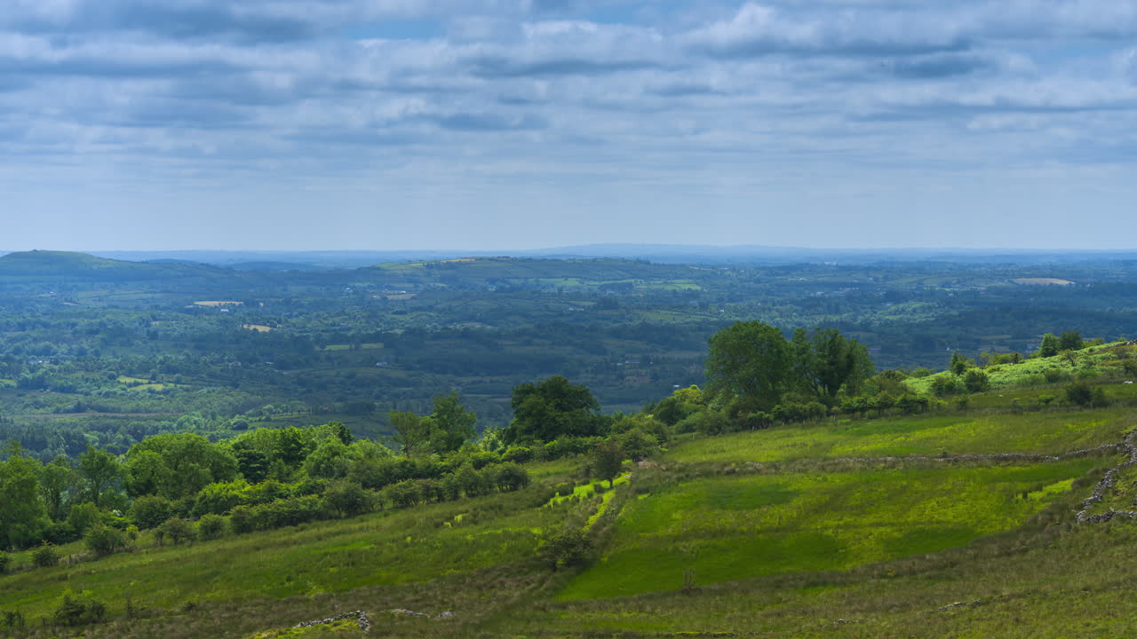 Time lapse of rural farming landscape with a trees and sheep in the distance on a spring sunny cloudy day in Arigna mountains in county Leitrim in Ireland