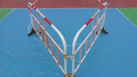 a view of a colorful basketball court blocked by barriers at a closed playground due to covid-19 coronavirus outbreak and restrictions in hong kong