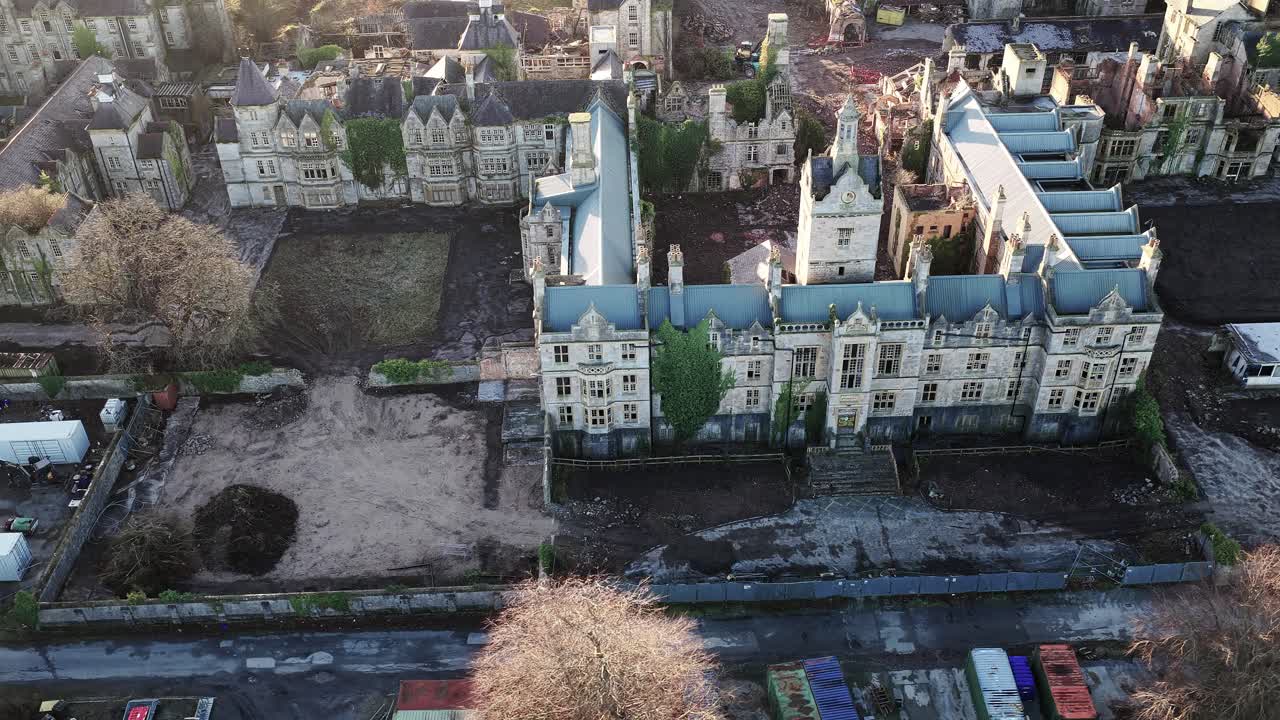 Veduta aerea dall'alto del complesso dell'ex manicomio di Denbigh con vecchi edifici suggestivi in rovina illuminati dal sole
