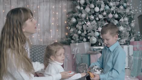 mum in white sweater looks after children playing with toys