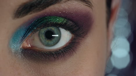 cerrar macro mujer apertura de ojos usando maquillaje colorido concepto de celebración de fiesta de año nuevo