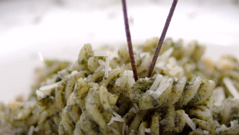 pesto fusilli with grated cheese, close-up, mediterranean