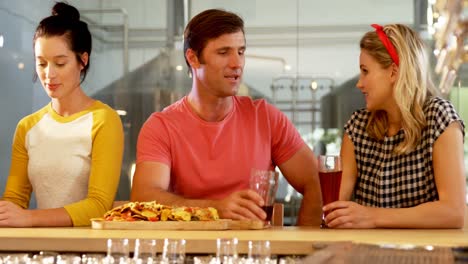 amigos interactuando entre sí mientras toman un vaso de cerveza 4k