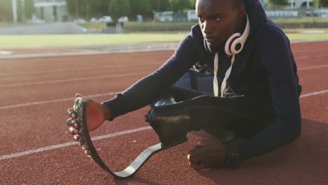 disabled mixed race man with prosthetic legs stretching before a race