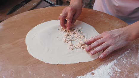 cerca de las manos haciendo un pastel con relleno de queso