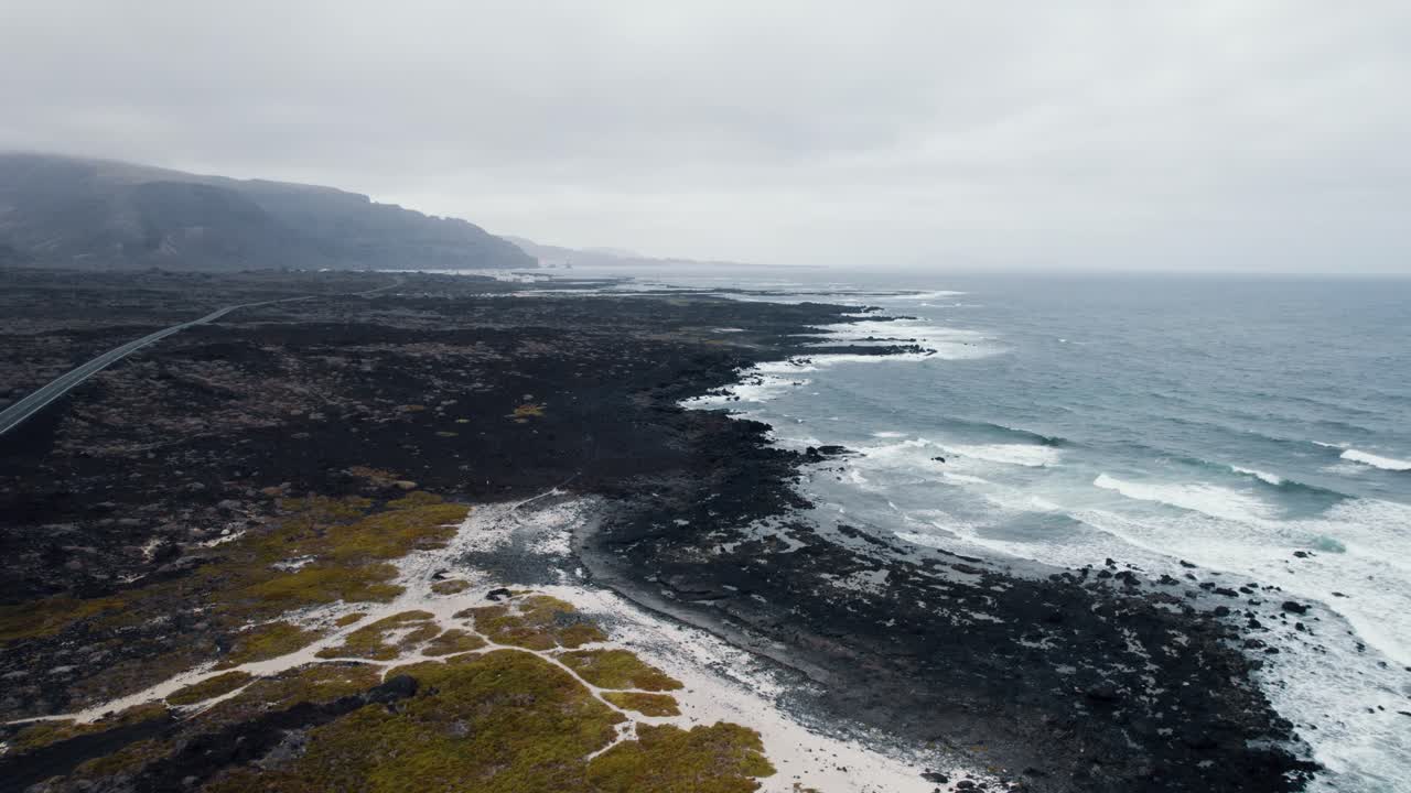 이국적인 검은 모래 해변, 거친 물결 모양의 바다 4k의 공중 촬영