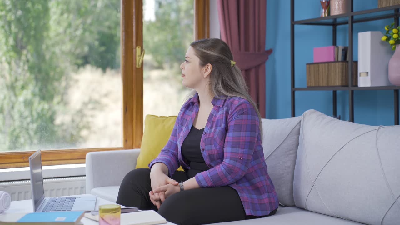 창문 앞에서 젊은 여자는 꿈을 꾸고 웃고 있습니다.