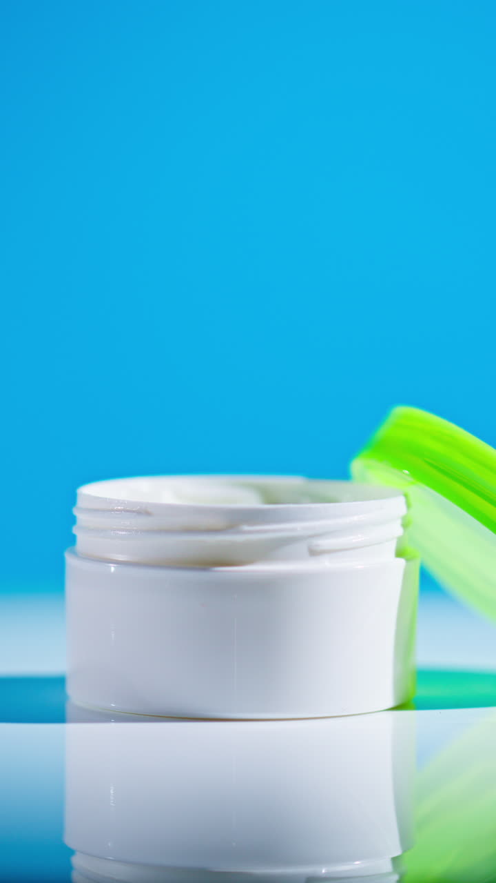 Open White Plastic Jar of Cream with Green Lid