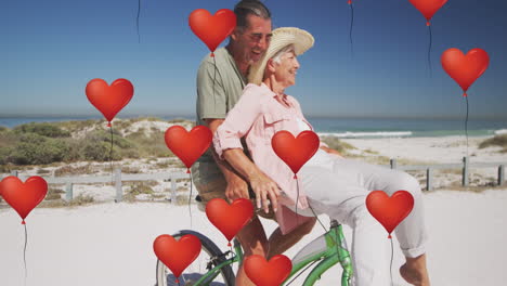 animación de iconos digitales de globos de corazón sobre una pareja de ancianos montando en bicicleta en la playa