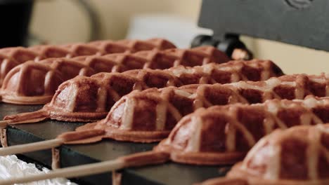 person flipping mini waffles in a waffle toaster