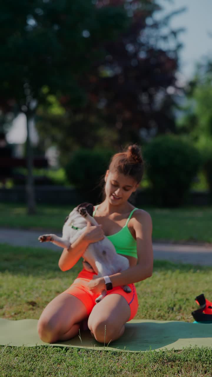 mujer haciendo yoga con un pug en el parque