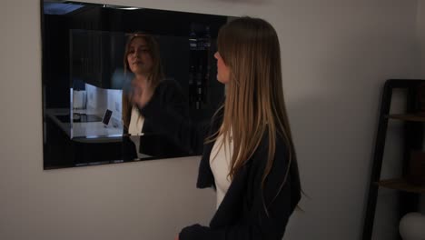 modelo femenino limpiando un espejo con una cocina en el reflejo