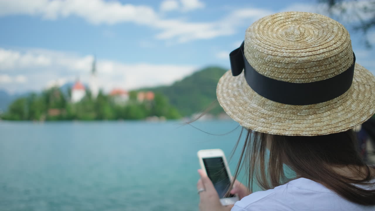 mujer tomando una foto de un hermoso lago