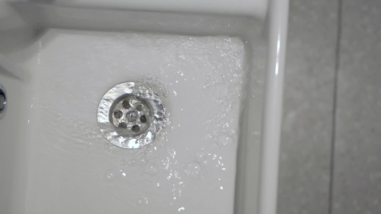 싱크대 배수관으로 물이 흘러들어가는 것