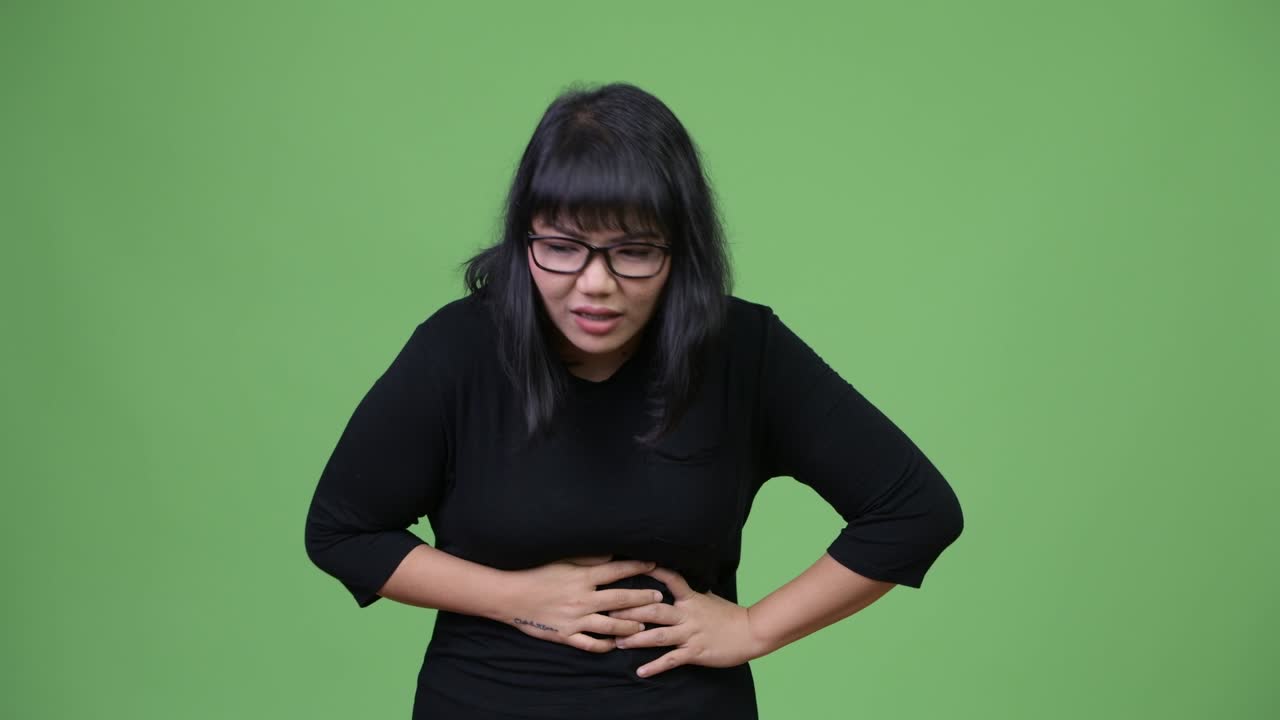 Beautiful Asian businesswoman having stomach ache