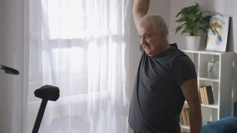 Un-Hombre-Adulto-Con-Bigote-Está-Haciendo-Gimnasia-En-Casa-Por-La-Mañana,-Un-Estilo-De-Vida-Saludable-Para-Las-Personas-Mayores-Que-Mantienen-La-Salud-Del-Cuerpo