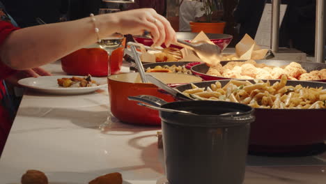 people get their food from a buffet with several hot and cold dishes of different foods all-you-can-eat style