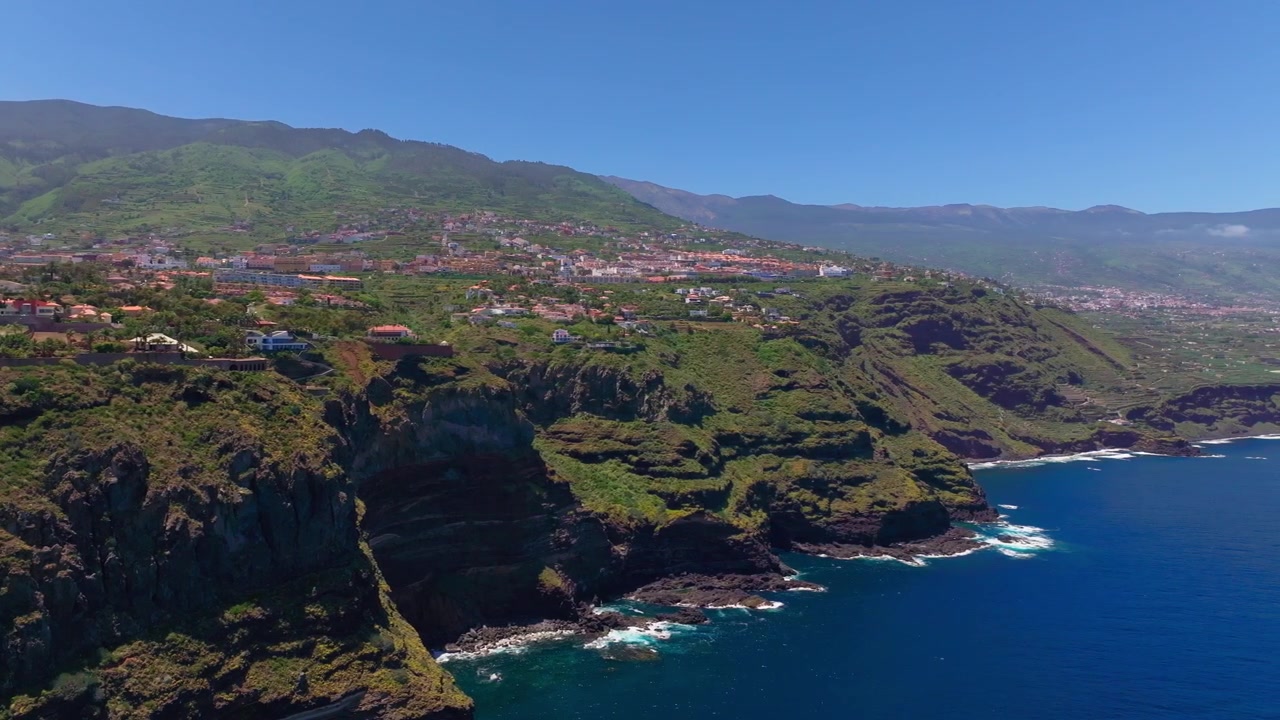 Vista aerea di scogliere verdi e aspre e villaggi costieri sopra le acque blu dell'Atlantico