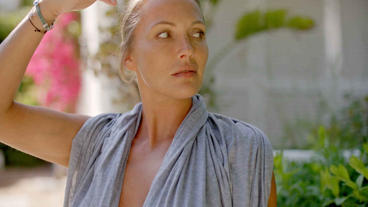 야외에서 카메라를 보고 회색 가운에 여자