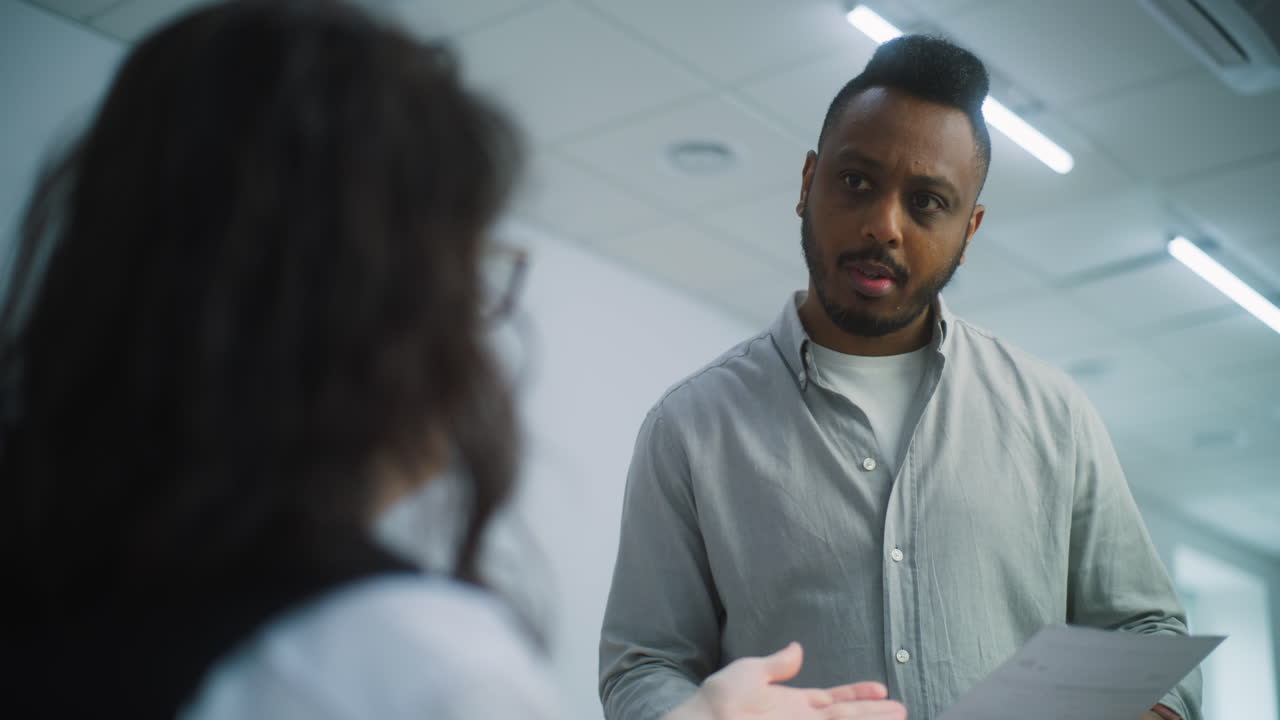 African American Male Voter Talks with Female Polling Officer African American Man Takes Paper Ballot for Voting at Polling Station Male Voter Talks with Female Polling Officer National Election Day in the United States of America Civic Duty and Democracy