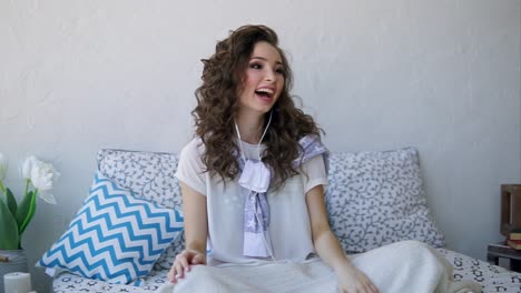 una mujer joven escuchando música en su dormitorio.