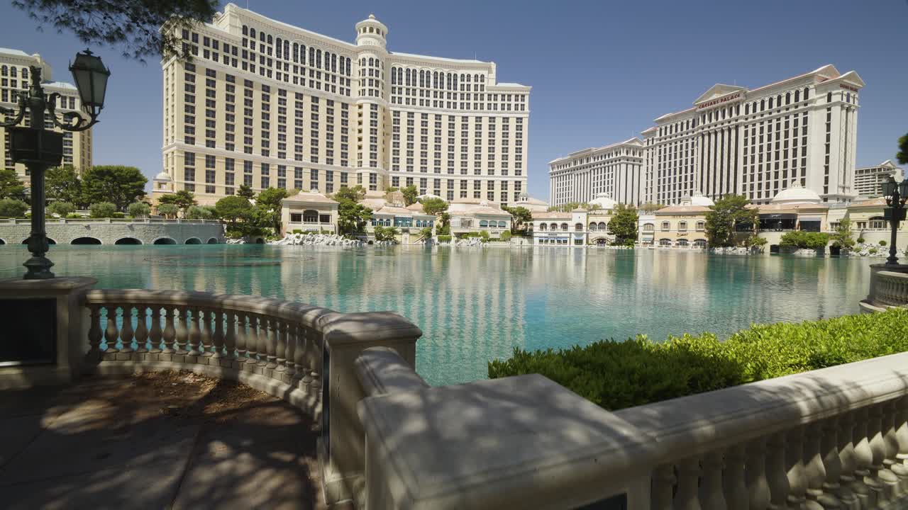 A jib up reveal of the Bellagio fountains, which are no longer running during the COVID-19 pandemic on the Las Vegas Strip. The sidewalk is empty.