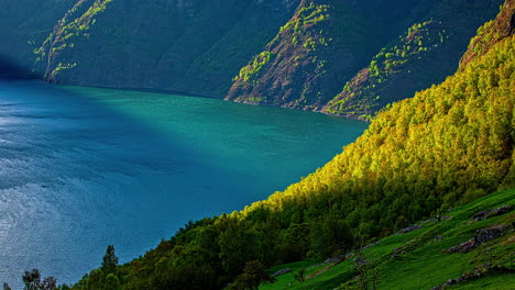 Time-lapse-shot-of-rapid-flowing-stream-of-Norwegian-Fjord-during-sunny-day-between-greened-mountains-in-autumn