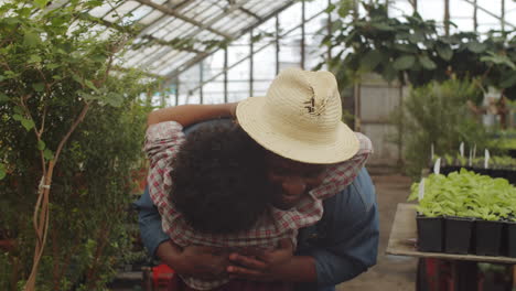 african american dad bonding with son in greenhouse