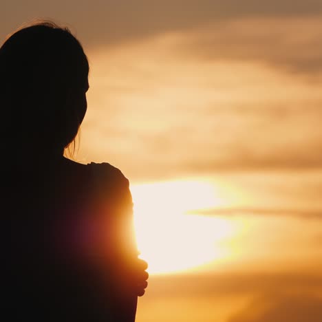 Silhouette-Einer-Jungen-Nachdenklichen-Frau-Bei-Sonnenuntergang-Mit-Blick-In-Die-Ferne