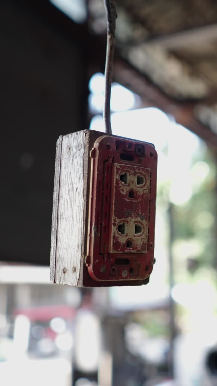 Old and Worn Electrical Outlet Hanging from a Wire