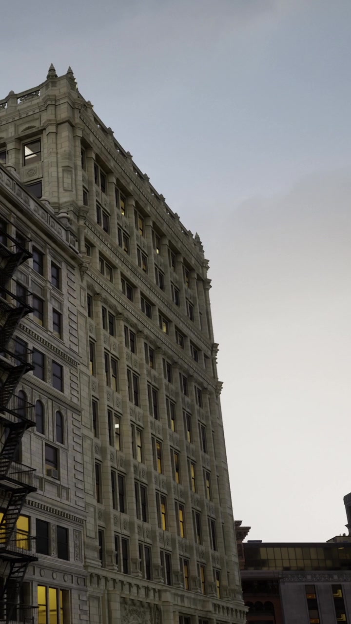 Edifício histórico com arquitetura detalhada em cenário urbano ao entardecer.