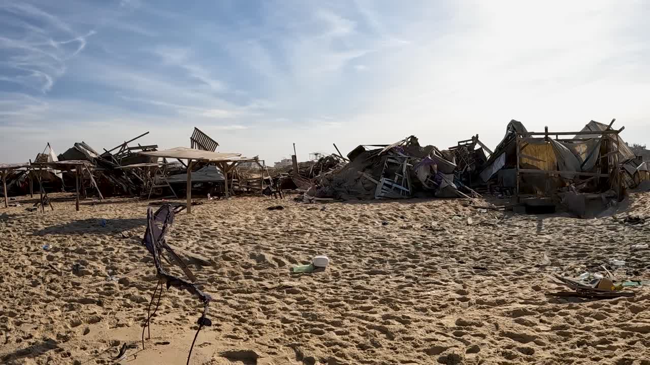 La telecamera rivela un rifugio di un campo profughi abbandonato e distrutto sulla spiaggia di Gaza durante il conflitto Israele-Hamas, 2024