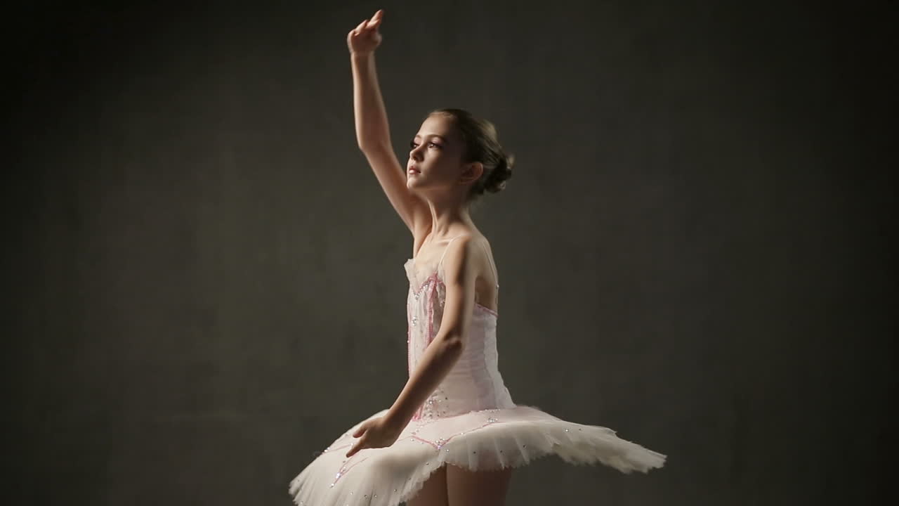 Young Ballerina Posing In Studio. Young beautiful girl ballerina against studio background